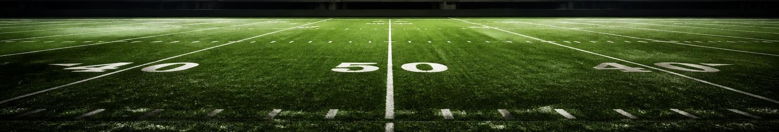 Empty NFL stadium at night under floodlights.